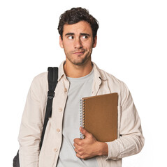 Young Hispanic student with notebook confused, feels doubtful and unsure.