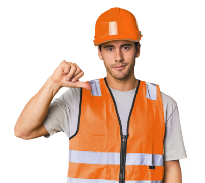 Young Hispanic worker in safety gear showing a dislike gesture, thumbs down. Disagreement concept.
