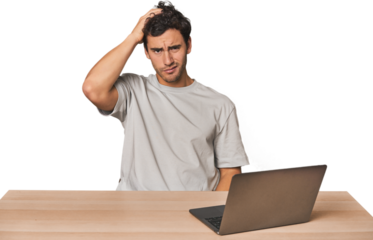 Hispanic young man working on laptop tired and very sleepy keeping hand on head.