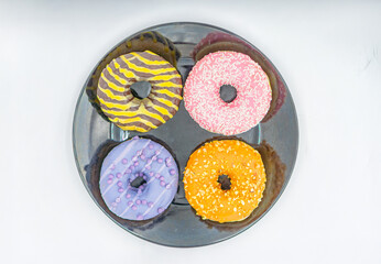 A colorful arrangement of six donuts on a plate, each with unique toppings and colors The...