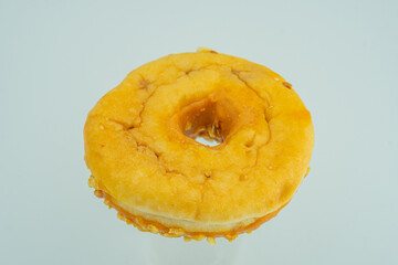 A close-up image of a freshly fried, golden-brown doughnut with bubbling patterns on its surface The background is neutral, focusing attention solely on the food item