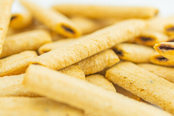 Close-up of golden brown, uneven textured pita chips with dark round toppings possibly olives or fruit Crispy edges emphasized Out-of-focus background No text present