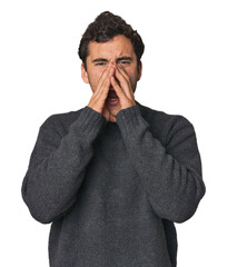 Young Hispanic man in studio shouting excited to front.