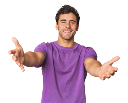 Young Hispanic man in studio feels confident giving a hug to the camera.
