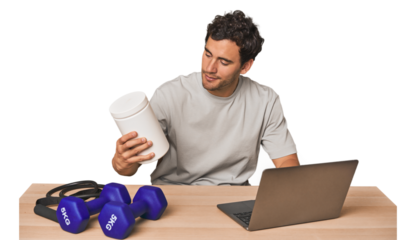 Hispanic male trainer with laptop planning workouts