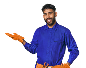 Hispanic worker in blue overalls in studio showing a copy space on a palm and holding another hand on waist.