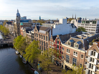 Historical Center of Amsterdam, Netherlands. Aerial Drone Shot of Traditional Dutch houses on narrow street and channel.