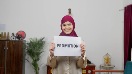 Muslim Woman in Hijab Scarf standing with Promotion Poster
