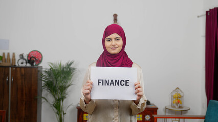 Muslim Woman in Hijab Scarf standing with Finance Poster