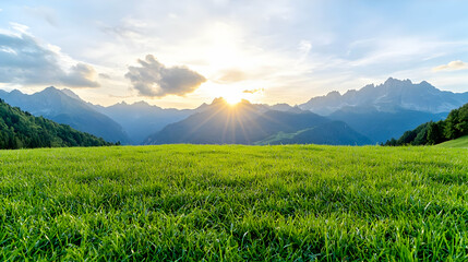 Fototapeta premium Sunset over green meadow, majestic mountains. Landscapes use