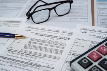 Polish PIT 11 37 38 tax form prepared to be filled with pen calculator glasses on desk