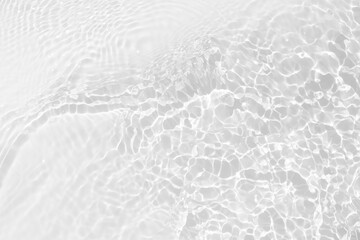 White water with ripples on the surface. Defocus blurred transparent white colored clear calm water surface texture with splashes and bubbles. Water waves with shining pattern texture background.