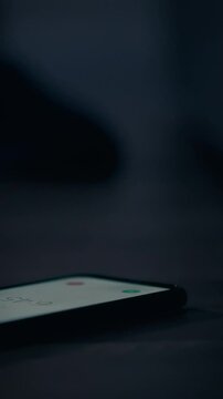 Close up of female hand reaching for phone to turn off alarm early morning at dusk. Early morning phone ringing hand looking for phone to turn off alarm. Sleepy girl lying on bed