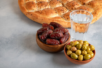 Dates fruit, green olives, Ramadan pita, and water for the iftar table
