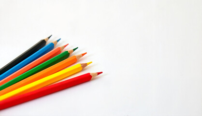 Fototapeta premium Colorful colored pencils arranged diagonally on white background with copy space