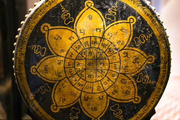A large drum carved with a gold-colored yantra pattern