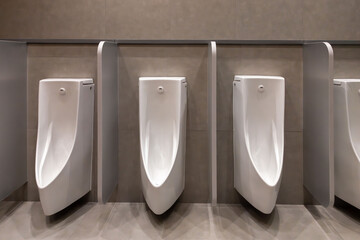 Three urinals are lined up in a row in a public restroom