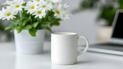 White mug on desk, daisies, laptop; home office