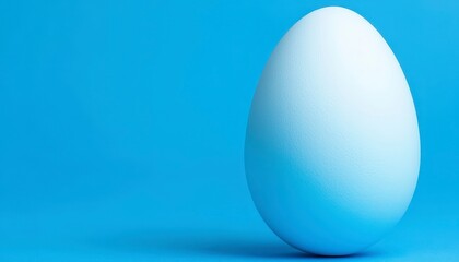 Fototapeta premium Single White Egg on Bright Blue Background in Minimalist Style
