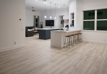Interior modern farmhouse kitchen with white cabinets and blue island, quartz countertop designed with contemporary finishes and gold hardware