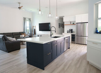 Interior modern farmhouse kitchen with blue island cabinets and white quartz countertop designed with contemporary finishes and wood floor tiles