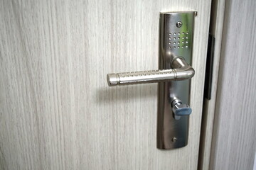 Close up of stylish silver chrome door handle on modern interior door. 