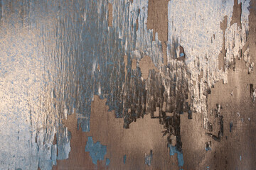 Plywood texture with golden and blue flaking peeling paint, abstract patterned backdrop