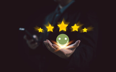 businessman holds glowing smiley face and five stars, representing excellent customer service, high...