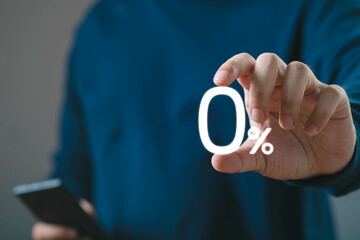 Close-up of a person holding a transparent zero percent sign, emphasizing concepts of finance, discounts, or interest rates