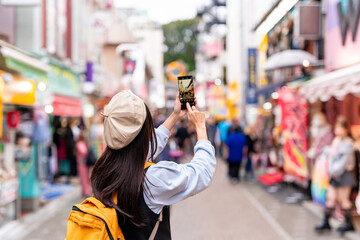 Young woman tourist walking on the Takeshita street in Harajuku the center of teenage fashion and cosplay culture in Tokyo