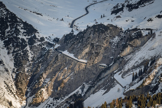 The snow-covered Flexen Pass Road with Flexen Gallery winds through steep rock walls in the Alps between Z&uuml;rs am Arlberg and Klostertal near Stuben in the Ski Arlberg skiing area.