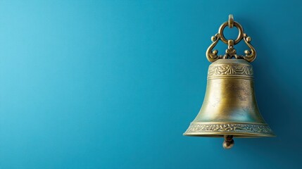 Decorative brass bell with a vintage design, isolated on a solid blue background.