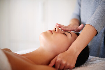 Face, massage and woman on table at spa for skincare, peace and acupressure with luxury hotel service. Relax, self care and girl on bed at beauty salon for holistic facial, wellness or skin treatment