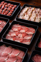 Freshly Sliced Meat Varieties Displayed in Black Trays