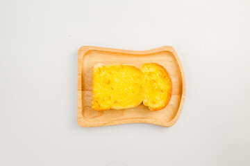 Delicious Garlic Bread Slice on Wooden Plate with Light Background