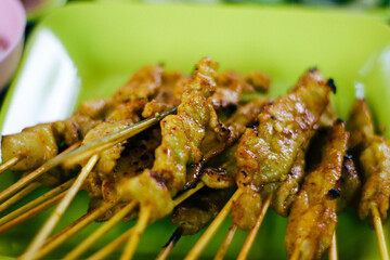 Grilled pork satay on skewers in Thai street food market