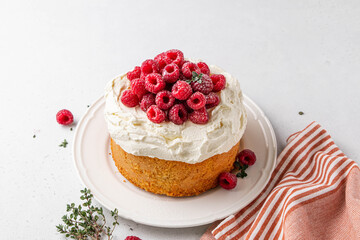 Homemade classic victoria vanilla sponge cake or biscuit or pie decorated with whipped cream and fresh strawberries on top on a light background. Summer dessert. Copy space. Selective focus.