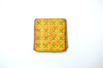 A single square biscuit with a green filling is centered on a clean white background, showcasing its simple and appetizing appearance