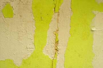 Green damaged plaster on concrete wall, old plaster needs repair. Abstract background, close-up, copy space