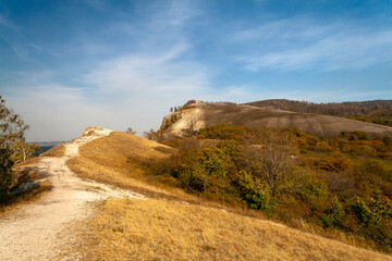 Magnificent Coastal View with Towering Cliffs, Lush Greenery, and the Deep Blue Sea Under a Partly Cloudy Sky