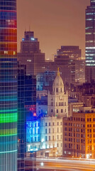 Obraz premium City Skyline Glowing With Vibrant Rainbow Colors Against a Night Backdrop of Urban Architecture