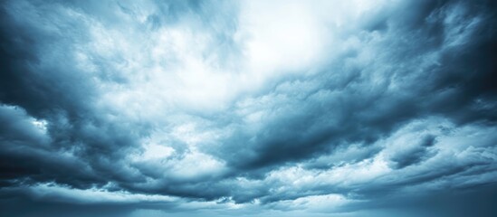 Obraz premium Dramatic cloud formation in a blue sky with gray tones suitable for weather and nature themes Copy Space