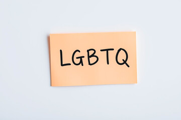 Text LGBTQ on pink note on white background
