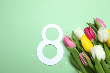 8 March, International Women's Day. Figure eight with beautiful tulips on a color background. Space for text