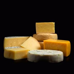 Different types of cheese. Spectacular lighting, pure black background, deep shadows. High-quality, bright composition