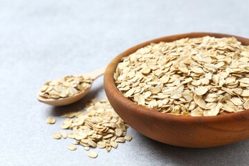 Composition with oatmeal flakes on gray background. Cooking breakfast