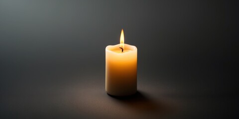 Single glowing candle with a warm flame on a dark background.