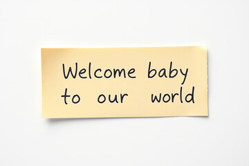 Text Welcome baby to our world on yellow note on white background