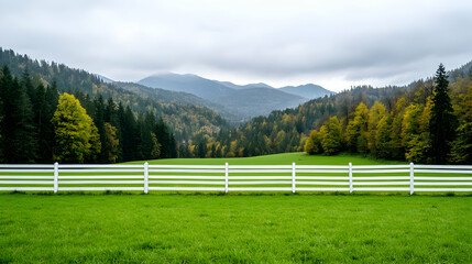 Autumnal mountain valley view, green field, white fence