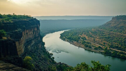 Fototapeta premium A Serene River Cuts Through a Rugged Landscape at Golden Hour Showing High Cliffs